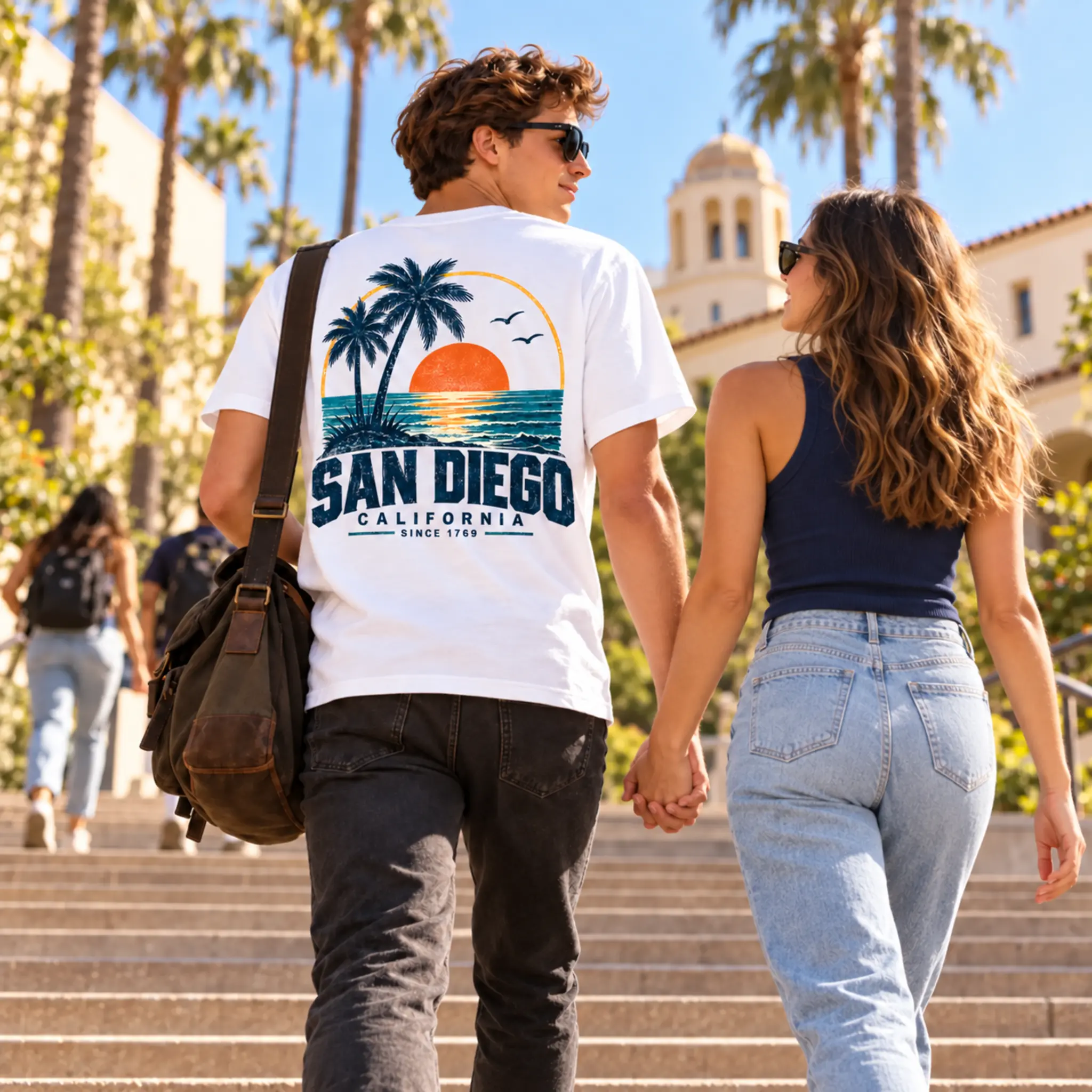 College couple holding hands and walking up campus stairs in San Diego Sunset Palms apparel